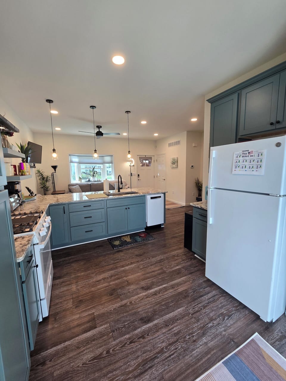 Open area from back slider to front door. Pendant lighting over counter.
