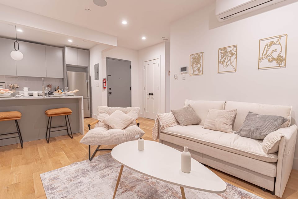 Open-concept boho living area flows into modern kitchen with island and dining space.