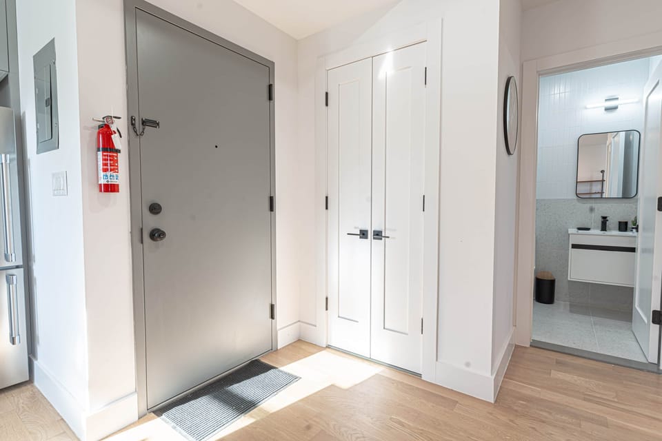 Bedroom with queen bed, smart TV and warm lighting in calm Scandinavian Bushwick retreat