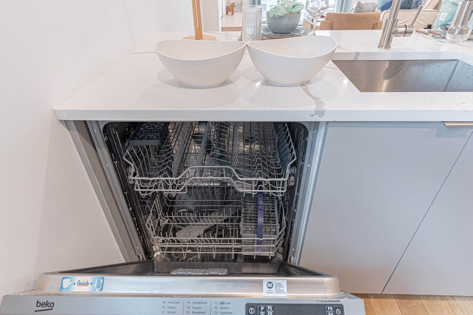 Built-in dishwasher in sleek Scandinavian kitchen for easy cleanup after shared dinners