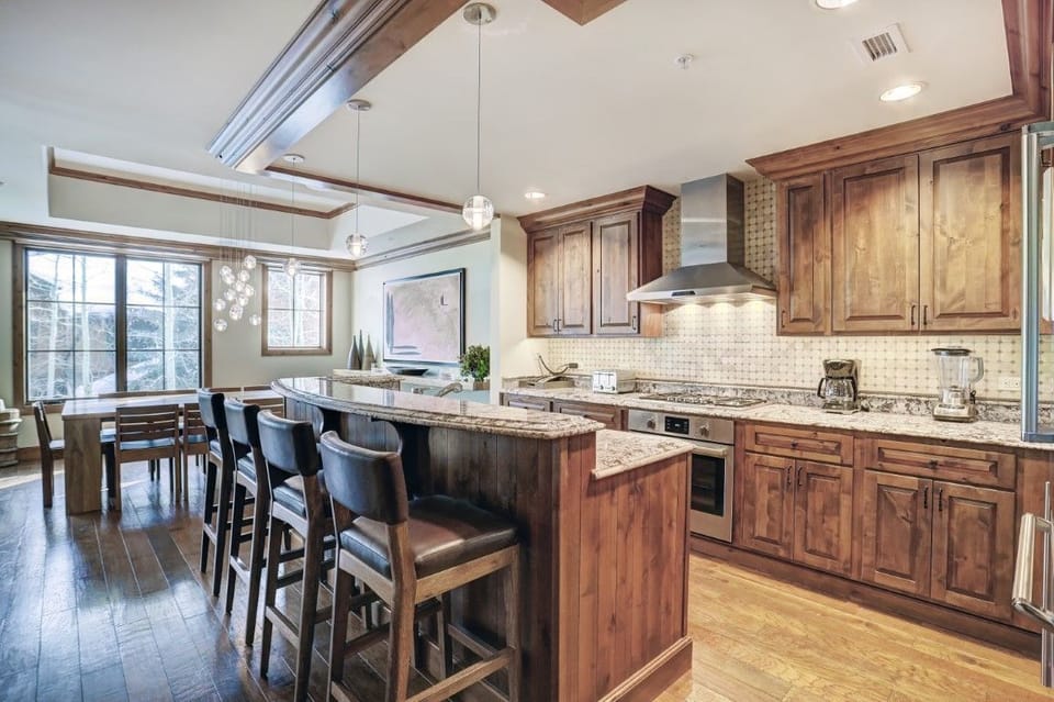 The modern kitchen boasts high-end appliances, granite countertops, and a stylish island, ideal for entertaining and preparing meals in luxury.