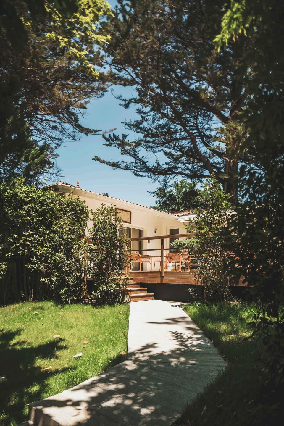Surrounded by lush greenery, the apartment opens onto a peaceful garden path — a quiet escape just steps from the sea.