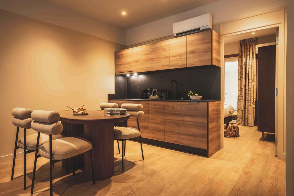 Warm, fully equipped kitchenette with modern wood finishes — perfect for preparing meals in the comfort of your apartment.