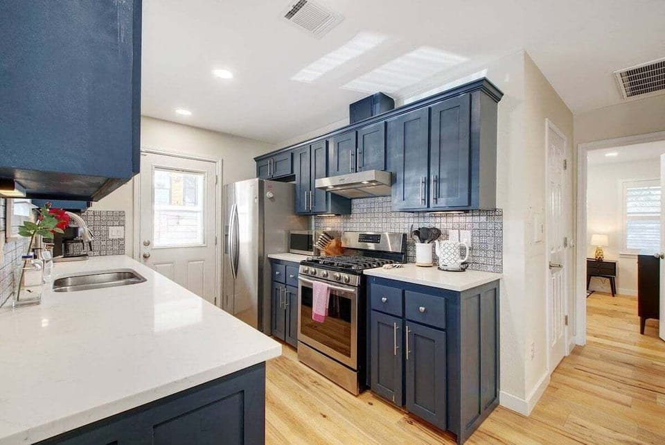 The kitchen includes Samsung and Whirlpool stainless steel appliances and other additional small appliances such as a toaster, blender, microwave, coffee maker, and more.