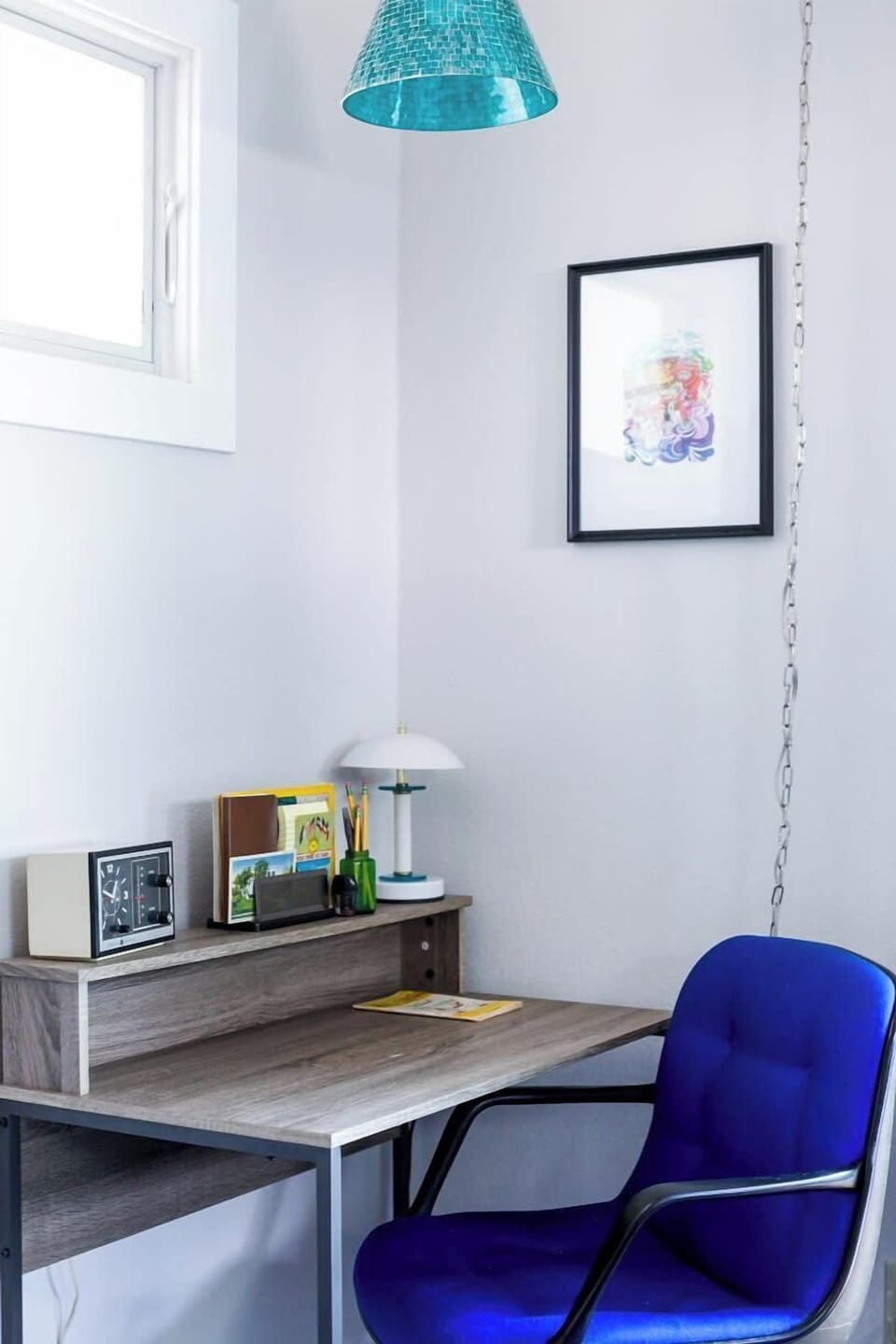 The corner of the Blue Suite hosts a desk with a vintage Steelcase chair, fun lighting options, and local vintage details.