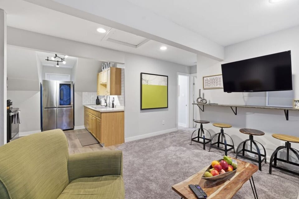 A bright and inviting upstairs living room with cozy seating, warm lighting, and a flat‑screen Roku TV. Enjoy “dinner and a show” at the floating bar, or unwind on the comfy sofa bed just steps from the full kitchen.