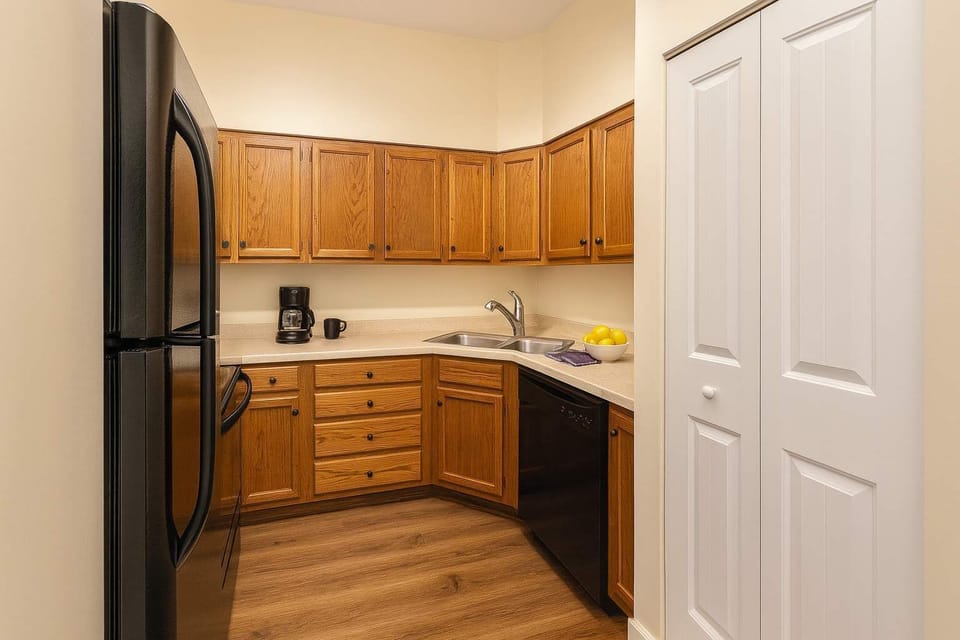 Kitchen coffee station with drip coffee maker, dishwasher, and full-size fridge.
