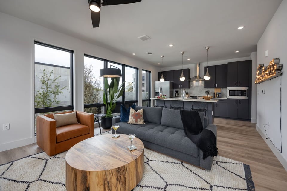 Unit 1: Bright living room with comfortable seating, smart TV, designer decor, and access to the private patio.