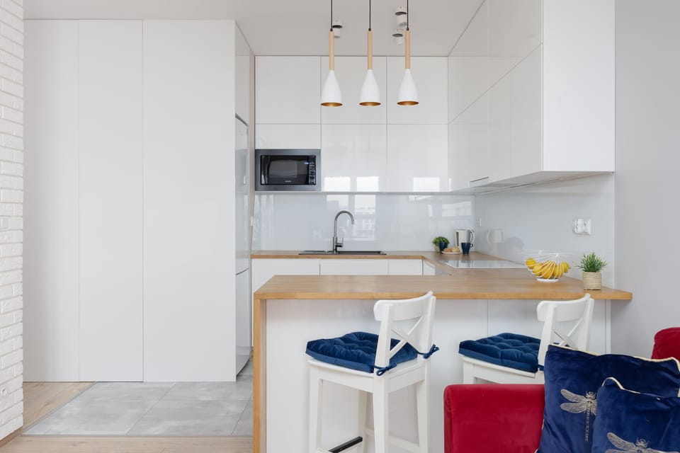 Kitchen and dining zone with coordinated white cabinetry and wooden countertops.