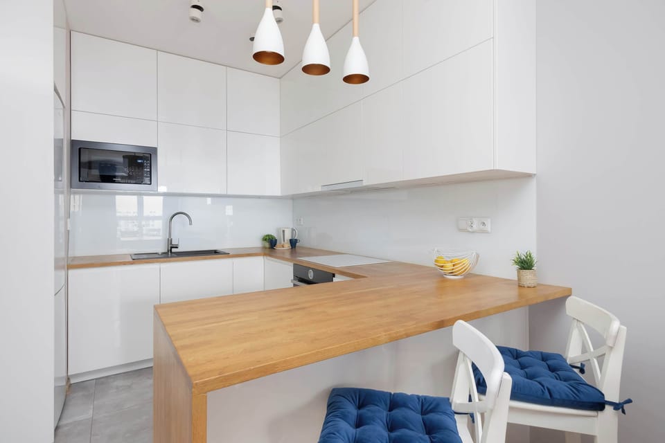 Bright, fully equipped kitchen with essential appliances and ample workspace.