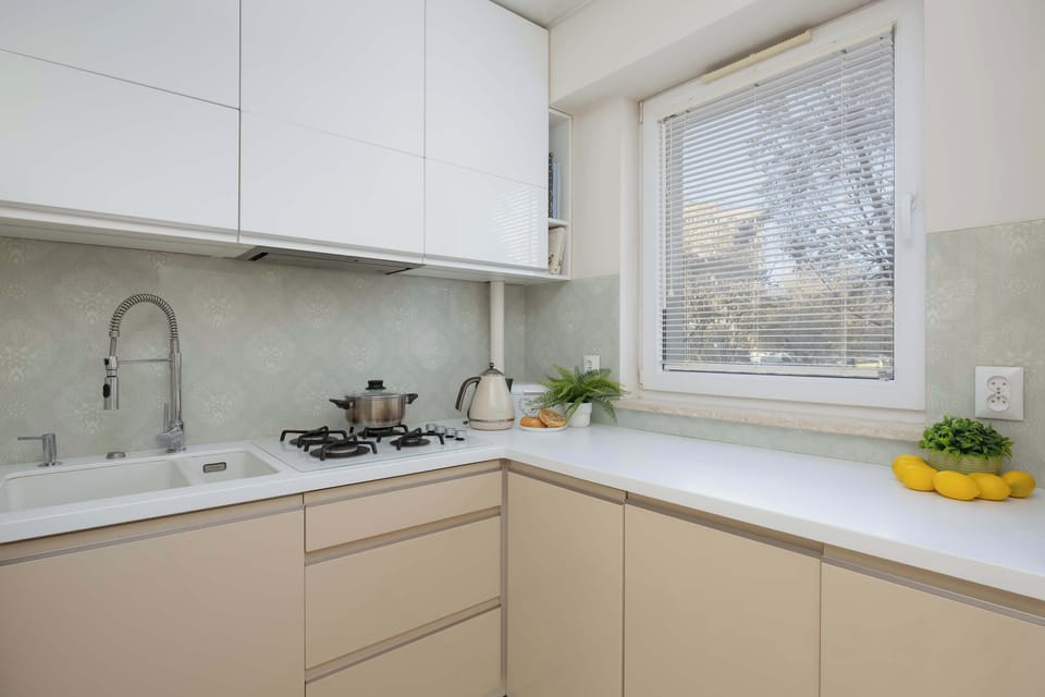 This view captures the kitchen sink area under a window, suggesting good light for meal preparation. A faucet and the integrated countertop are clearly visible.
