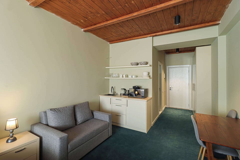 A comfortable sofa is positioned in front of a dining table, complemented by a lamp that provides warm lighting.