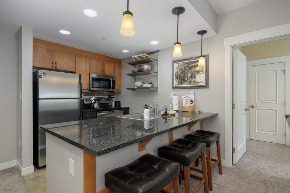 Your fully equipped kitchen features granite counters, stainless steel appliances, and a breakfast bar where you can start mornings with coffee.
