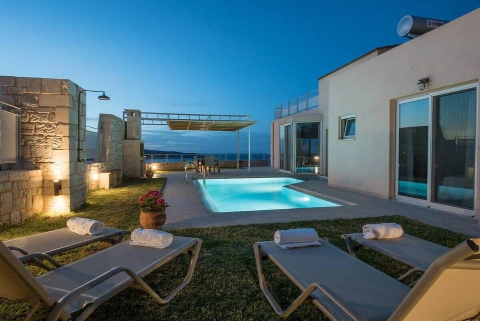 Chic Nighttime Retreat with Illuminated Pool and Ocean Vista