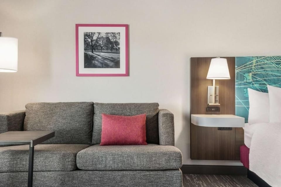 Unwind on the cozy sofa beside soft bedside lighting.