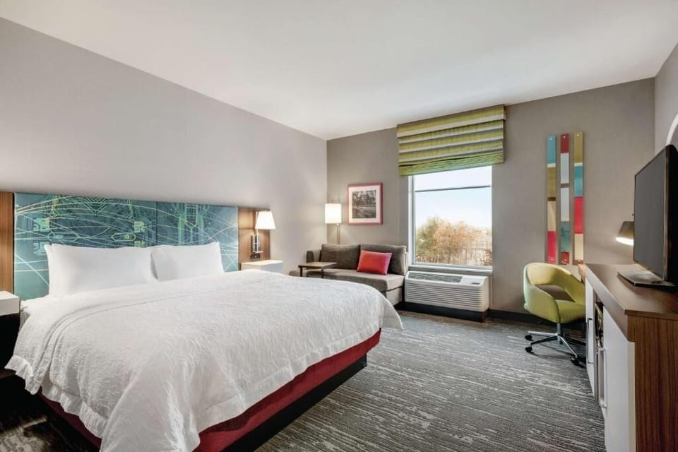 Unwind in a sunlit room with crisp linens and lounge sofa.