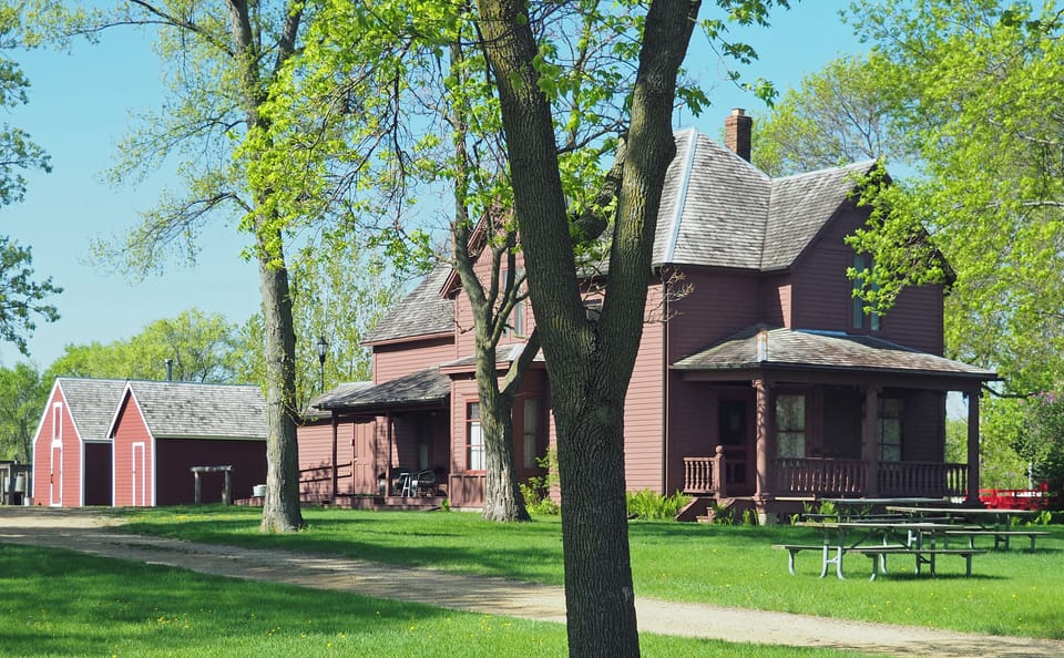Arrive to a charming country home framed by tall trees.