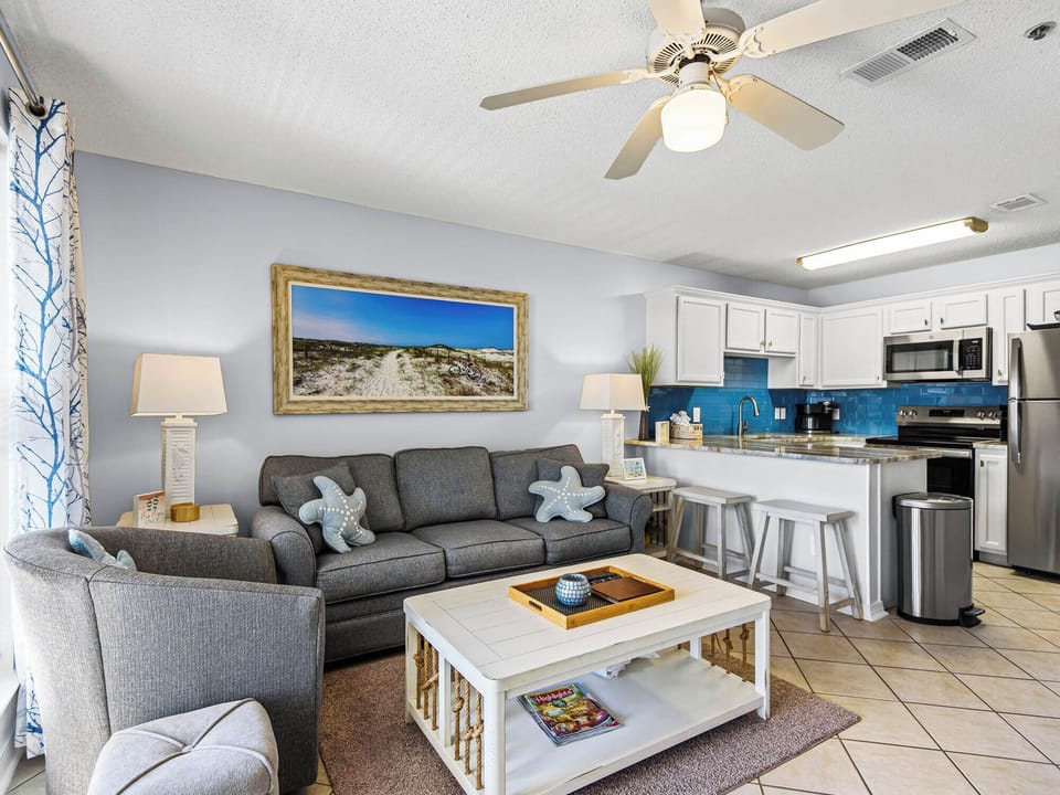 Relax in the bright, open-concept living space where coastal charm meets modern comfort with a fully equipped kitchen.