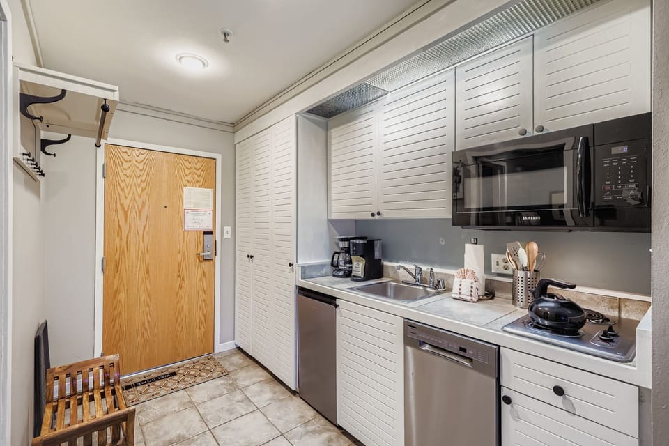 Your fully-equipped kitchen awaits with modern appliances and coastal-inspired louvered cabinets, making it easy to whip up your morning coffee or prepare a home-cooked meal during your stay.