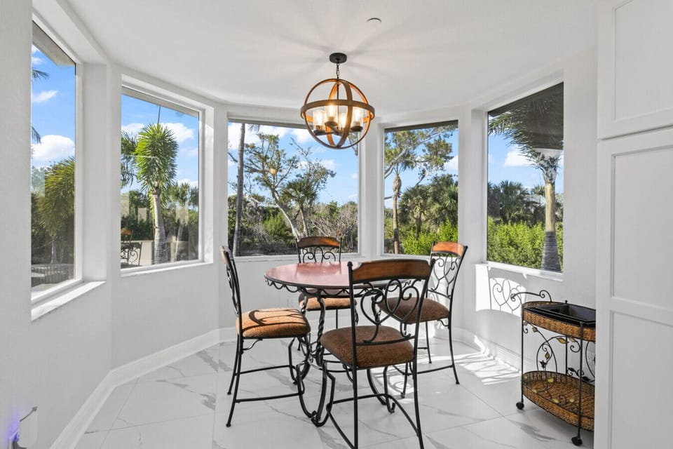 Sunlit breakfast nook with tropical treetop views.