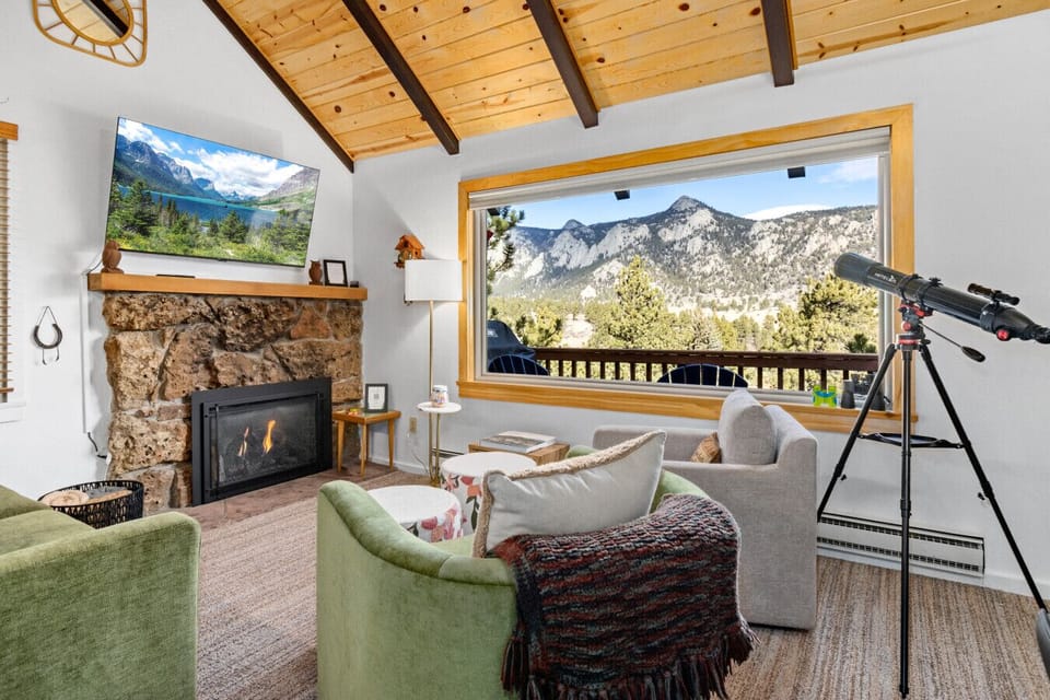 Bright, open living room with fireplace and mountain views. Enjoy glazing at the stars at night!