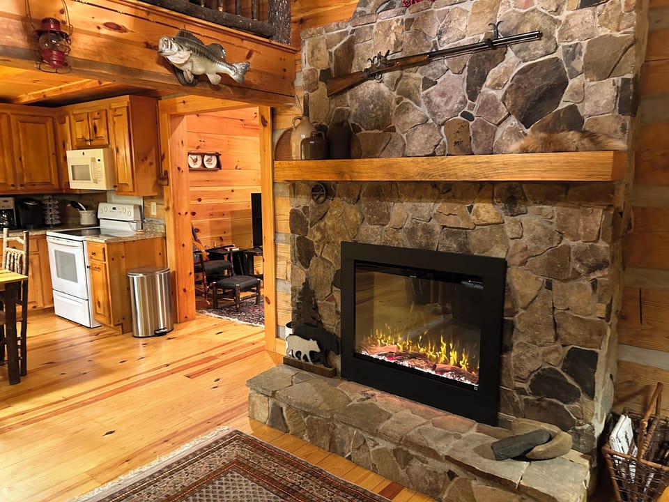 Sitting room hearth, vaulted ceiling, entry to kitchen and dining area