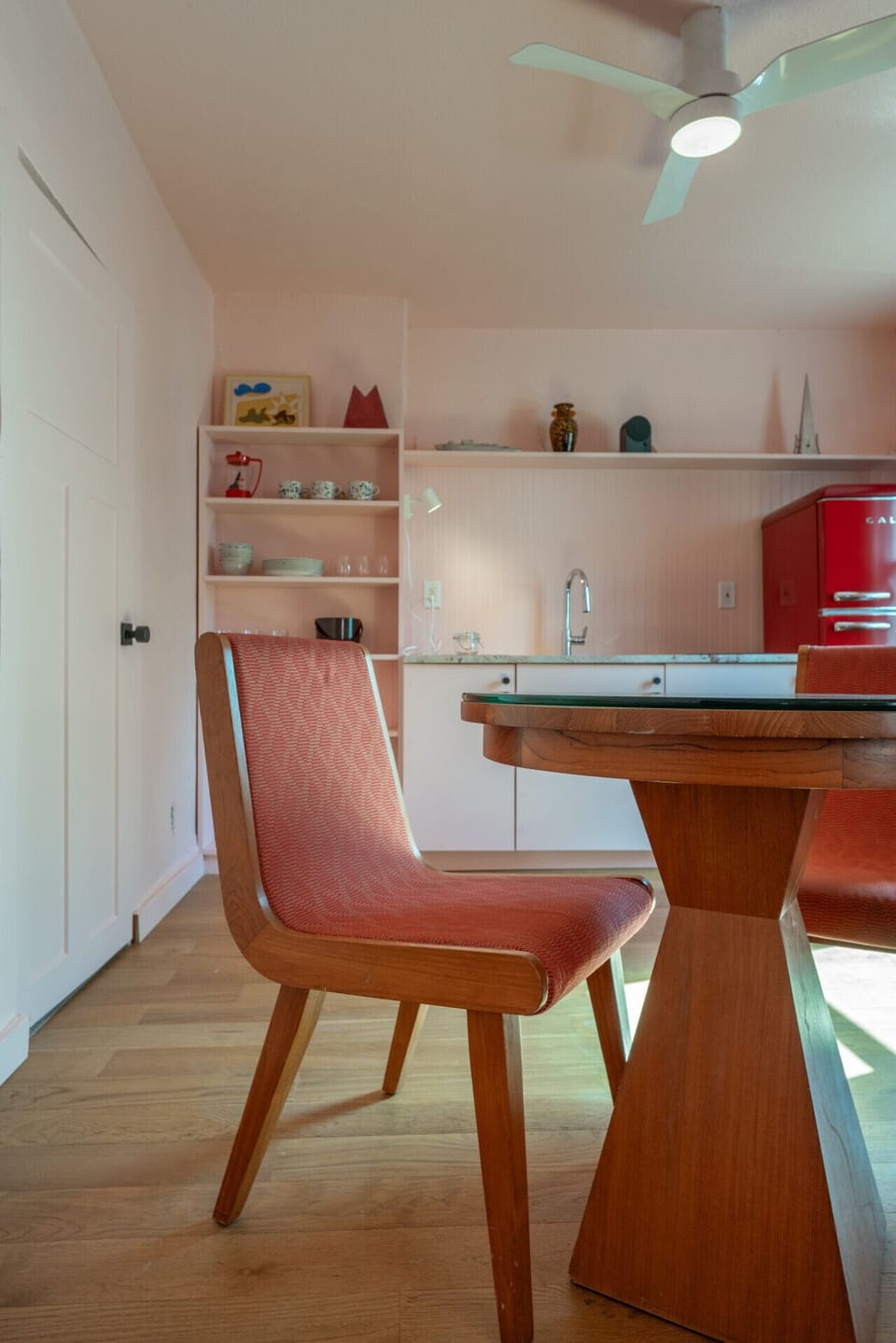 Dining Detail: Vintage dining chair with a view into the pastel kitchen.