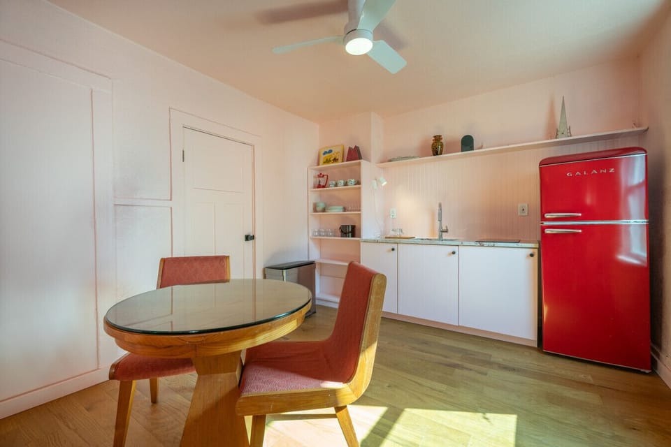 Dining Area: Sunny breakfast nook with a round wood table and stylish red chairs.