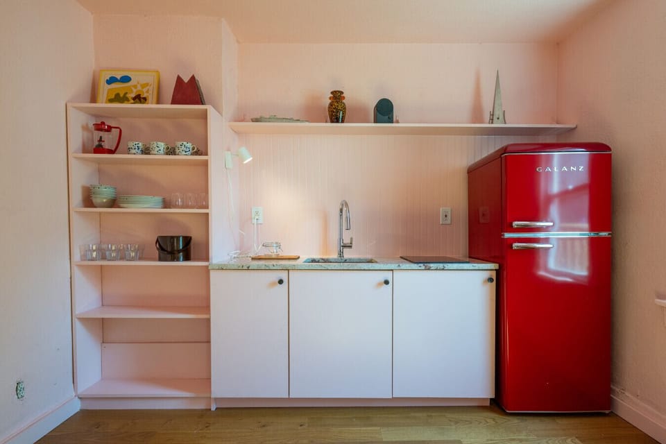 Kitchen Close-Up: Retro red fridge and pastel kitchen ready for your next meal.