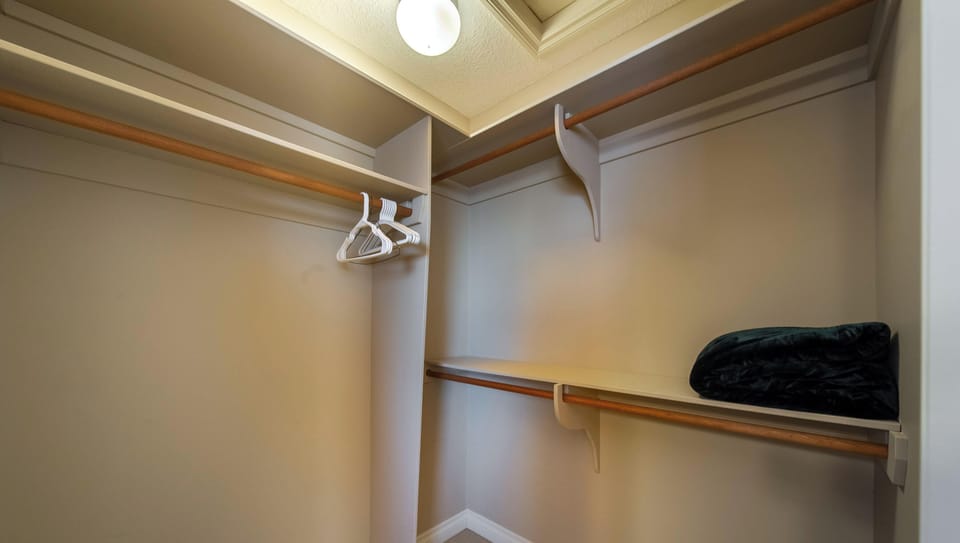 Ensuite features walk-in closet, glass shower, and relaxing corner tub with tile