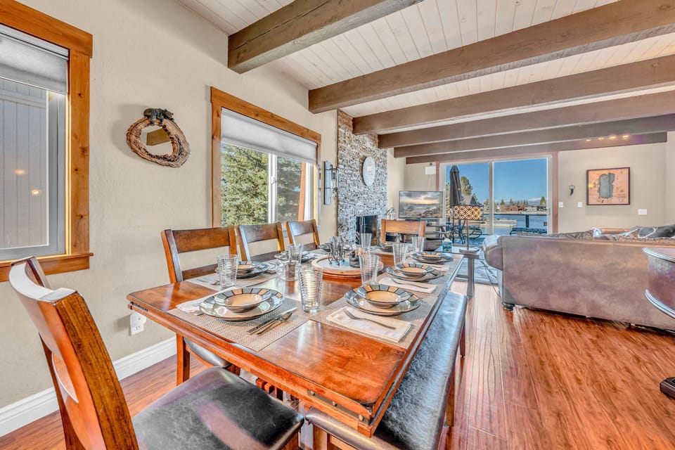Dining Area: Large family table beside open kitchen with bar seating and bright windows