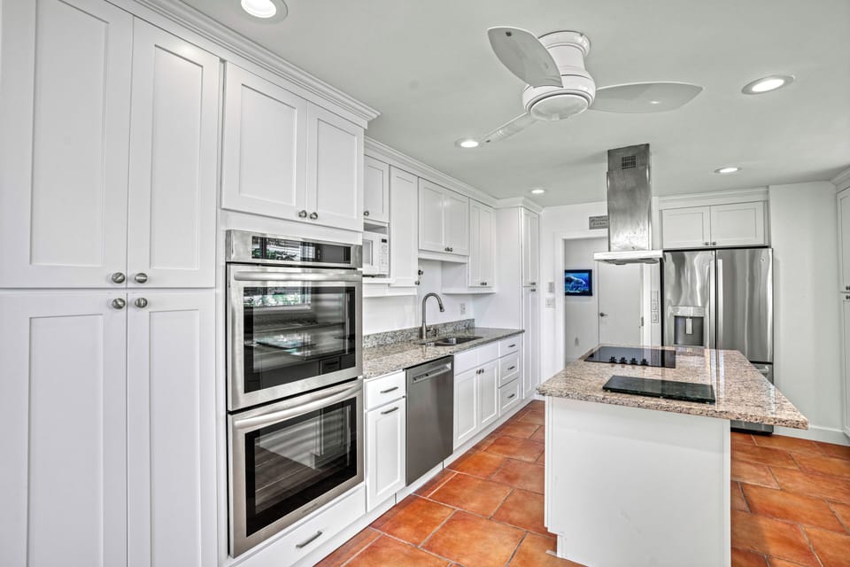 Prepare meals effortlessly in the bright kitchen, featuring a spacious island, double ovens, and a sleek sink.