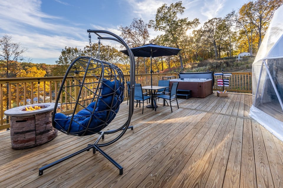Spacious private deck with fire table, hanging egg chair, dining area, and a relaxing hot tub—perfect for unwinding day or night.