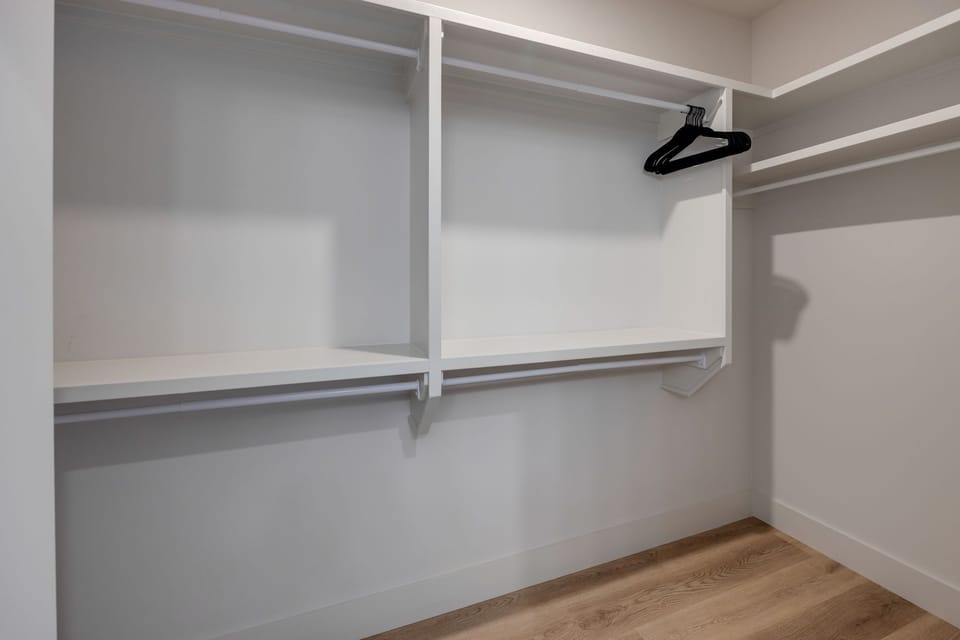 Unit 1: Primary Bedroom with King bed, smart TV, floor to ceiling windows, and en-suite bathroom.