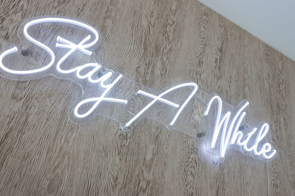 Unit 1: Bright open living space featuring a smart flat-screen TV, designer furnishings, and access to the private patio.