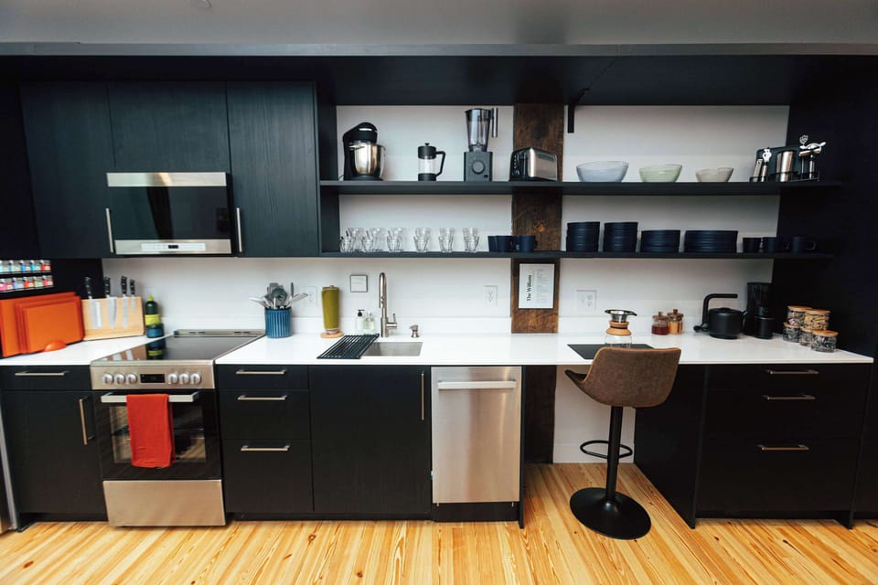 Fully equipped kitchen with sleek black cabinetry and everything you need for simple meals or craft cocktails.