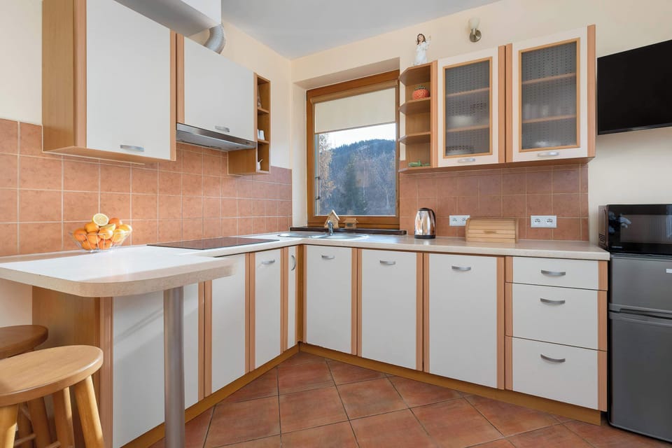 Fully equipped kitchen with wooden cabinets, a stove, and a dining area.