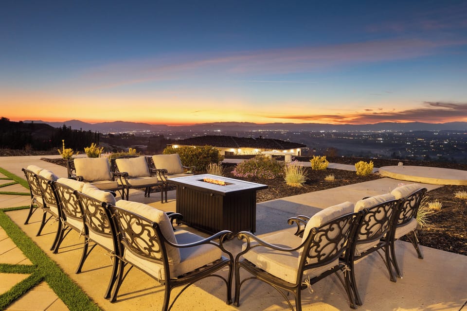Outdoor lounge area with fire table and panoramic views.