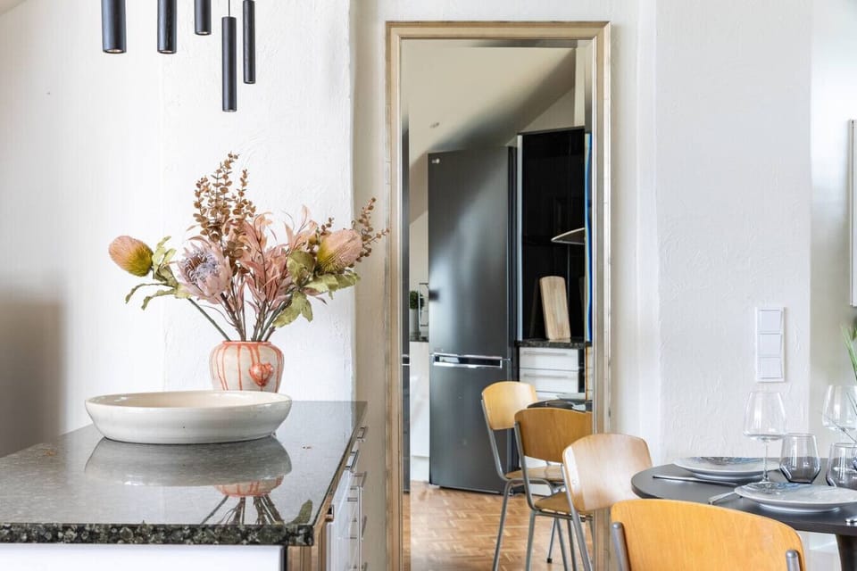 Inviting dining area beside the kitchen, thoughtfully set with full tableware, cutlery, and wine glasses — perfect for cozy dinners or entertaining guests.