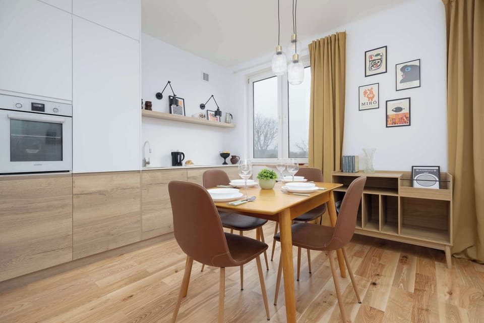 Inviting dining space with a wooden table, elegant brown chairs and natural daylight streaming in.