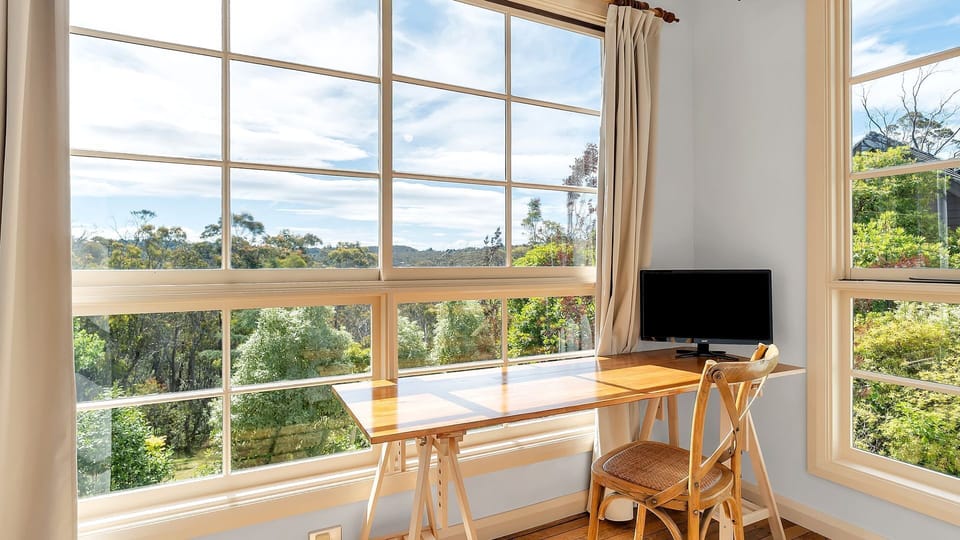 Relaxed work or dining space with expansive treetop scenery.