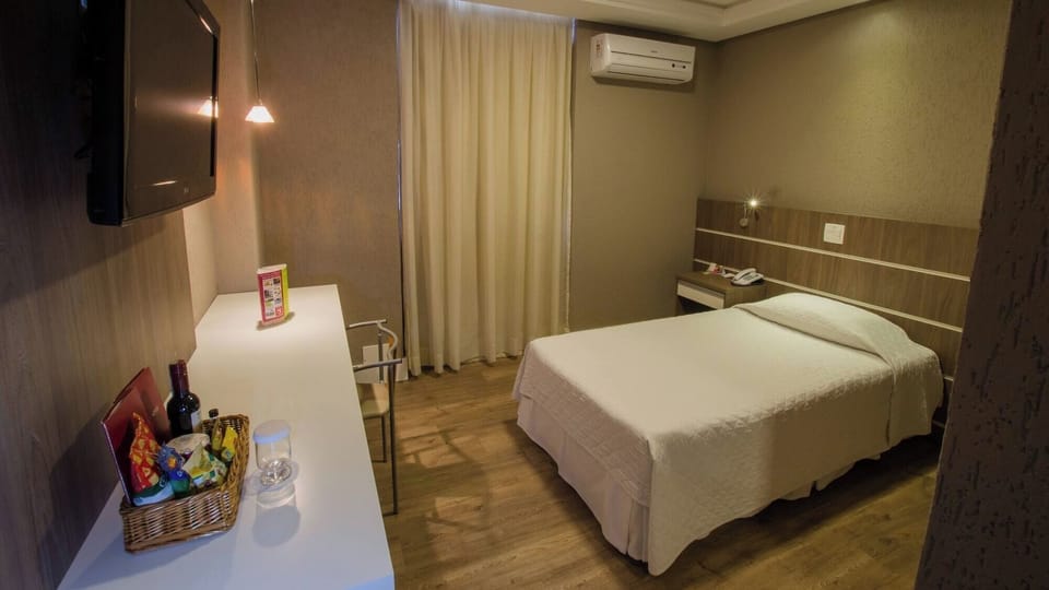 Recharge in a cozy queen bed beside a practical work desk.