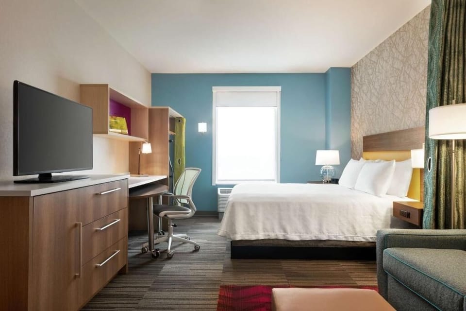Settle in with a cozy bed, desk workspace, and TV