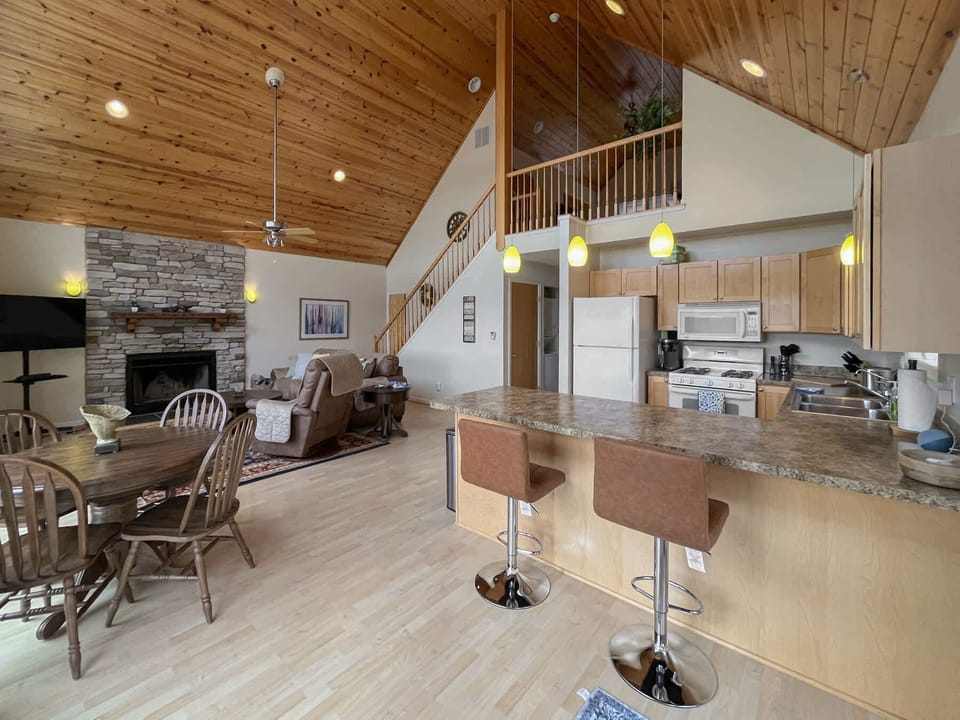 The open floor plan connects a cozy living area, dining space, and fully stocked kitchen — perfect for spending time together.
