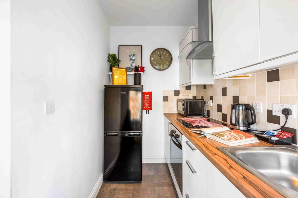 Bright kitchenette with laminate countertops, cupboards, and a sense of airy, seaside charm