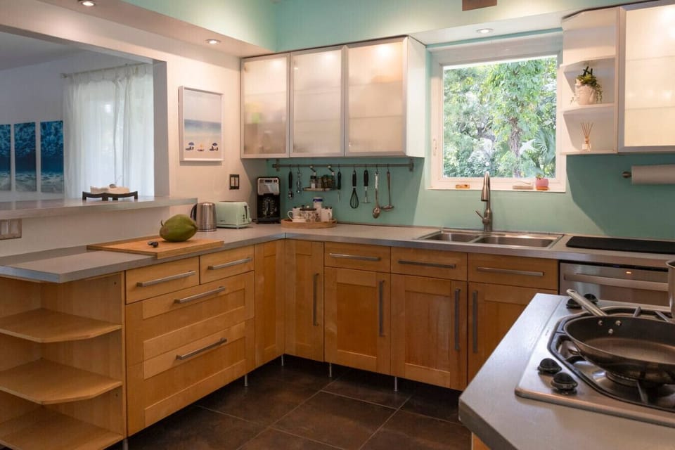 Modern fully equipped kitchen with stainless steel appliances, gas stove, and all cooking essentials.