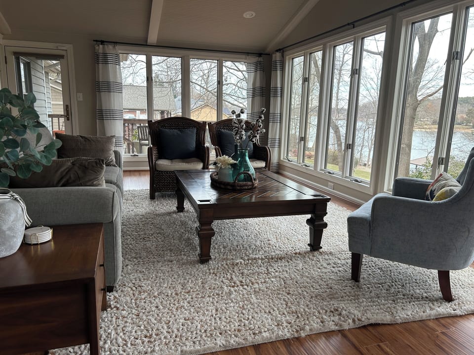 Sunroom with large windows, lake and tree views