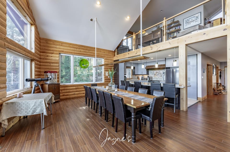 Spacious dining and living area with vaulted ceilings and loft view