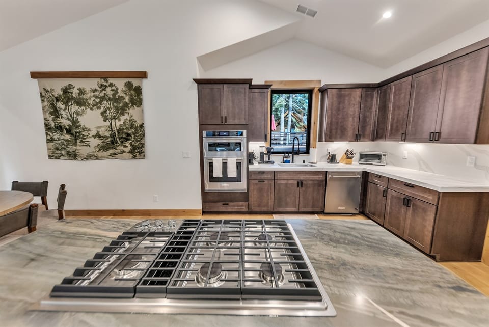 Kitchen with 5-burner gas range and with built in microwave/convection oven combo and full oven.