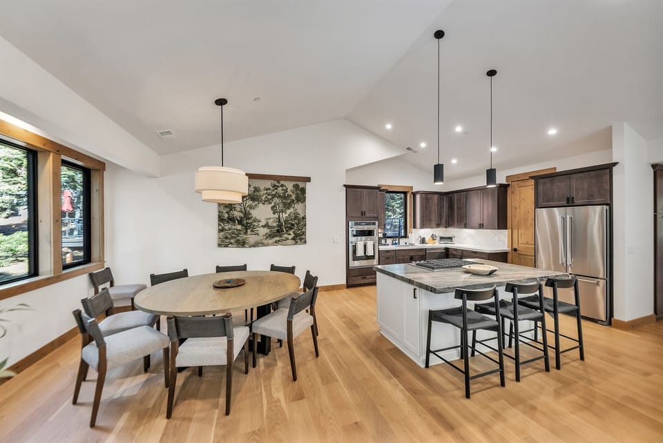 Custom round dining table with seating for ten adjacent to large open kitchen.